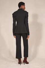 Blazer negro de corte recto de la colección Zara Studio, con solapas de muesca, cierre frontal de dos botones y bolsillos con solapa. Presenta mangas largas con pliegues estructurados en los hombros y forro interior a rayas a contraste.