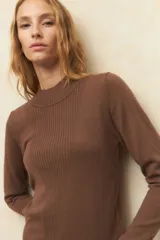 Polera color borgoña de tejido de punto con cuello alto y mangas largas.