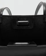 Bolso tipo shopper color negro, confeccionado en poliuretano con acabado brillante y efecto arrugado, con asas largas y costuras verticales decorativas en el frente.