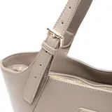 Cartera tipo tote de diseño curvo, confeccionada en cuero sintético color gris. Presenta asas regulables con hebillas metálicas y un aplique triangular metálico con el logo de la marca en el frente.