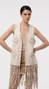 Chaleco de efecto gamuzado color beige, con detalles tejidos al crochet en forma de rombos, flecos largos en el ruedo y diseño sin mangas.