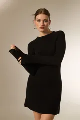 Vestido corto de punto acanalado, color negro, con cuello redondo a la base y mangas largas.