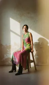 Vestido largo sin mangas, con estampado abstracto en tonos rosas, verdes y dorados, confeccionado en microtul.