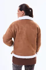 Campera de estilo aviador en color negro, confeccionada en material tipo gamuza con interior y bordes de corderito blanco. Presenta cierre frontal, cuello con solapas y hebilla metálica decorativa.