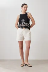 Top negro sin mangas con bordado blanco en el frente y contorno.