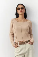 Remera blanca de manga larga con cuello redondo y costuras a la vista.