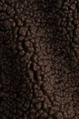 Chaleco de sherpa color marrón con cuello elevado, cierre frontal y bolsillos tipo parche delanteros. Presenta ribetes de cinta y forro interior.