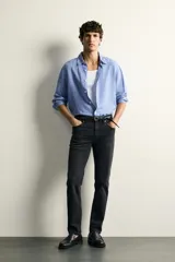 Jeans slim fit de tiro medio, color celeste claro con efecto lavado. Confeccionados en tejido elástico, cuentan con diseño de cinco bolsillos y cierre frontal con cremallera y botón metálico.
