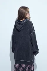 Buzo tipo canguro de calce relajado con efecto lavado desgastado. Presenta costuras a la vista en contraste, bolsillo frontal tipo canguro y capucha integrada.