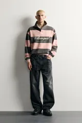 Jeans de denim de algodón en color azul con efecto desgastado, tiro medio y corte recto de ajuste holgado (loose fit). Cuenta con diseño clásico de cinco bolsillos y cierre frontal con cremallera y botón.