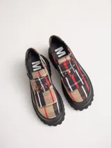 Mocasines con plataforma de goma negra, confeccionados en lona con estampa a cuadros en tonos violeta, amarillo y beige, y detalle de elásticos laterales ocultos.