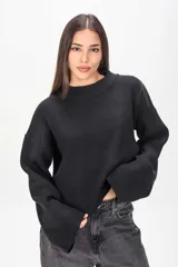 Sweater negro de punto acanalado, con cuello redondo y mangas largas anchas.