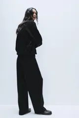 Pantalón de punto de tiro alto con bolsillos delanteros y bolsillos de plastrón en la parte trasera. Presenta una cintura doble ajustable con cordón en tejido a contraste.