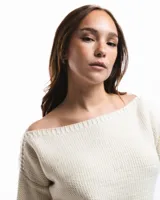 Buzo de lana merino con cuello bote y mangas largas. Presenta un detalle bordado a mano en color azul en la parte inferior.