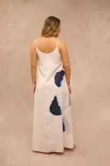 Vestido largo color blanco con diseño estampado floral de gran tamaño en tonos azules y rosados, tirantes finos y escote en V.