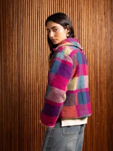 Chaquetón corto de lana con diseño de cuadros en tonos tierra y borravino, con solapas amplias y cierre frontal de botones.