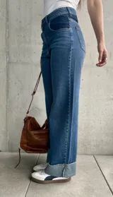 Pantalón de jean de tiro alto, color azul con detalles en azul oscuro en los bolsillos delanteros.