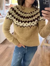 Sweater tejido a mano con diseño de canesú estampado en tonos marrón, crema y verde sobre base color tostado. Presenta cuello redondo, puños y ruedo acanalados.