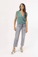 Pantalón de jean celeste de corte mom, con tachas plateadas.