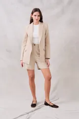 Bermuda color beige de lino y viscosa, tiro medio, corte recto y largo a la rodilla.