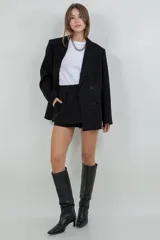 Mini short negro con sobre falda y detalles de brillo sutil.