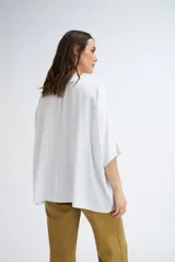 Blusa blanca de manga corta, con escote en V y cuello mao.