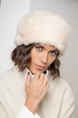 Gorro tipo ruso confeccionado en piel sintética de textura suave y densa, en color crudo.