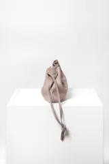 Bolso tipo sobre de cuero color rojo, con frunce superior y cierre con cordones. Tiene correa larga desmontable y bolsillo interno con cierre.