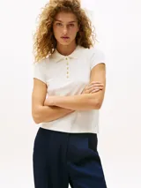 Chomba de manga corta color blanco hueso, con cuello de polo y cartera de cinco botones dorados. Presenta un corte slim y un pequeño logo bordado en el bajo.