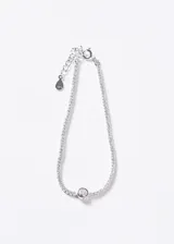 Pulsera de plata 925 estilo tennis, decorada con circonias brillantes y un punto de luz central más grande. Cuenta con cadena de extensión y cierre de mosquetón.