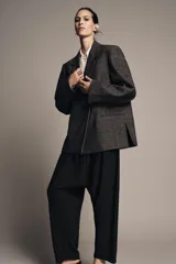 Blazer Zara Woman Collection confeccionada en tejido con lana, de corte oversize. Presenta cuello con solapas de muesca, cierre frontal cruzado con un botón y bolsillos de vivo en el delantero. Incluye forro interior.