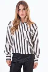 Camisa de manga larga con diseño de rayas verticales en color blanco y negro, cuenta con cuello clásico, cierre frontal de botones y un bolsillo en el pecho.