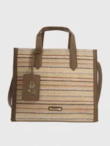 Cartera tipo tote de Hush Puppies con cuerpo de tejido trenzado en patrón de zigzag multicolor. Presenta detalles en cuero sintético marrón en las asas, bordes y base. Incluye un colgante decorativo con el logo de la marca y una placa metálica frontal con el nombre de la marca.