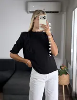 Blusa de símil lino color beige, con cuello redondo fruncido, doble volado en los hombros con detalle de encaje y manga 3/4.
