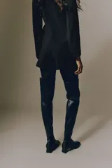 Short pollera de sarga color negro, diseño cruzado tipo envolvente en el frente y ajuste entallado.