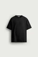 Remera de corte relaxed fit confeccionada en tejido de algodón con textura irregular, cuello redondo y manga corta.