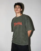 Remera de corte oversize boxy y estilo semi crop, color verde oliva con efecto lavado. Presenta estampa frontal con el logo de la marca en color rojo.
