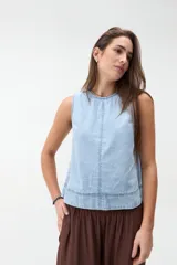 Blusa sin mangas de denim claro, corte recto y escote redondo con costuras decorativas frontales.