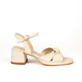 Sandalias de cuero color dorado, con plataforma y taco cuadrado. Presentan tiras cruzadas en el empeine y pulsera al tobillo con hebilla.