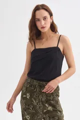 Musculosa negra de algodón con breteles finos y escote recto, con detalle de pliegues cruzados en el frente.