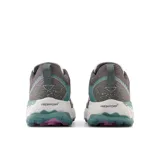 Championes de trail running New Balance Fresh Foam X Hierro v7 para mujer. Capellada de malla color gris con detalles en verde agua y verde claro. Suela Vibram Megagrip blanca con detalles en verde agua.