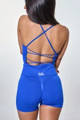 Conjunto deportivo de dos piezas color azul, compuesto por un top corto con breteles finos y logo estampado, y un short de tiro alto ajustado al cuerpo.