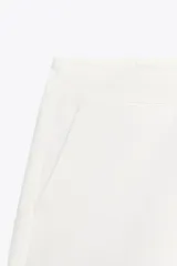 Shorts negros de tiro medio con cierre frontal de cremallera y gancho metálico. Presenta bolsillos delanteros ocultos en las costuras.