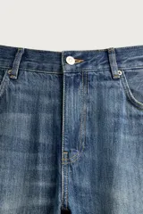 Jeans flare fit de tiro medio, confeccionados en denim de algodón color azul con efecto deslavado. Diseño ajustado en la parte superior y abierto en campana desde la rodilla, con cinco bolsillos y cierre frontal con cremallera y botón.