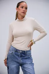 Polera básica de manga larga color beige, con cuello alto y tejido acanalado.