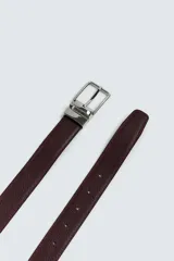 Cinturón reversible de cuero con textura granulada, pespuntes en los bordes y hebilla metálica de diseño clásico.