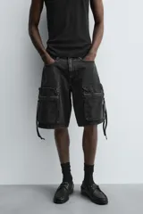 Bermuda de corte relajado en denim de algodón color beige, estilo cargo, con cinco bolsillos y bolsillos plastrón con solapa en las perneras.