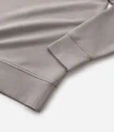 Buzo de cuello alto con cierre frontal parcial, manga larga y puños ajustados. Presenta un diseño minimalista en color verde militar.