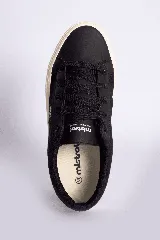 Zapatillas casuales color mostaza con cordones negros y suela blanca.