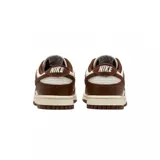 Championes Nike Dunk Low con diseño bicolor en tonos marrón y blanco. Presentan una silueta clásica de perfil bajo con paneles de cuero, puntera perforada para mayor ventilación y suela de goma resistente.